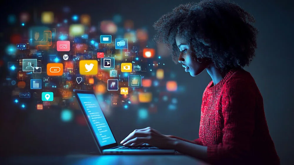 Femme sur son ordinateur portable, entourée d’icônes de réseaux sociaux